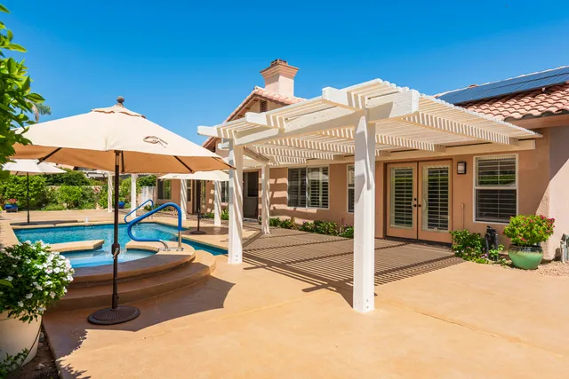 a view of a house with backyard and sitting area