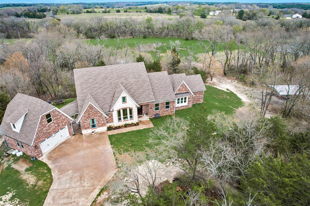 an aerial view of a house with yard and green space