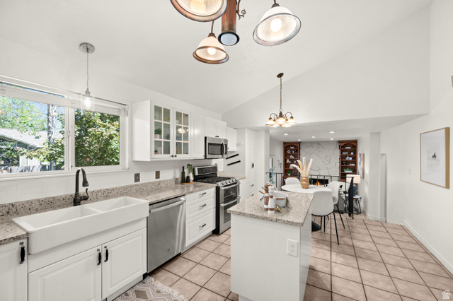 2163 Borg Drive Sandy, UT 84092 - Photo 6 of 31 Kitchen featuring white cabinets, stainless steel appliances, light stone countertops, lofted ceiling, and light tile patterned floors