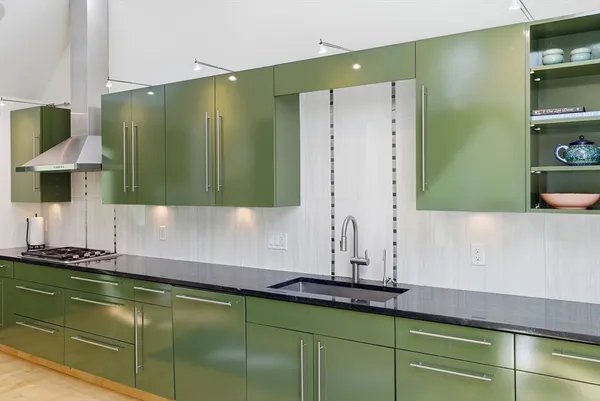 a kitchen with stainless steel appliances granite countertop a sink and a stove