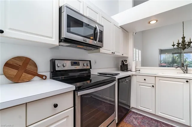 a kitchen with stainless steel appliances granite countertop a stove microwave and sink