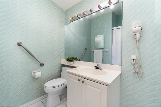 a bathroom with a sink mirror and toilet