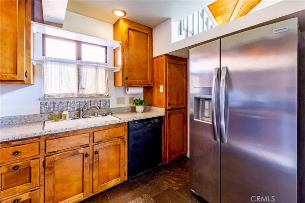 a kitchen with stainless steel appliances granite countertop a refrigerator and a sink