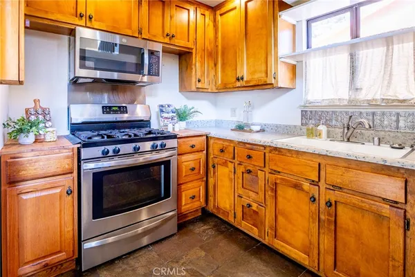 a kitchen with stainless steel appliances granite countertop a stove a sink and a microwave
