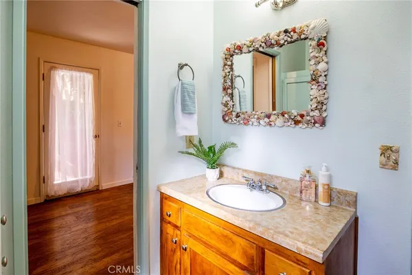 a bathroom with a granite countertop sink and a mirror