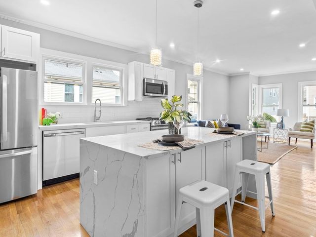 a kitchen with stainless steel appliances kitchen island granite countertop a sink and cabinets
