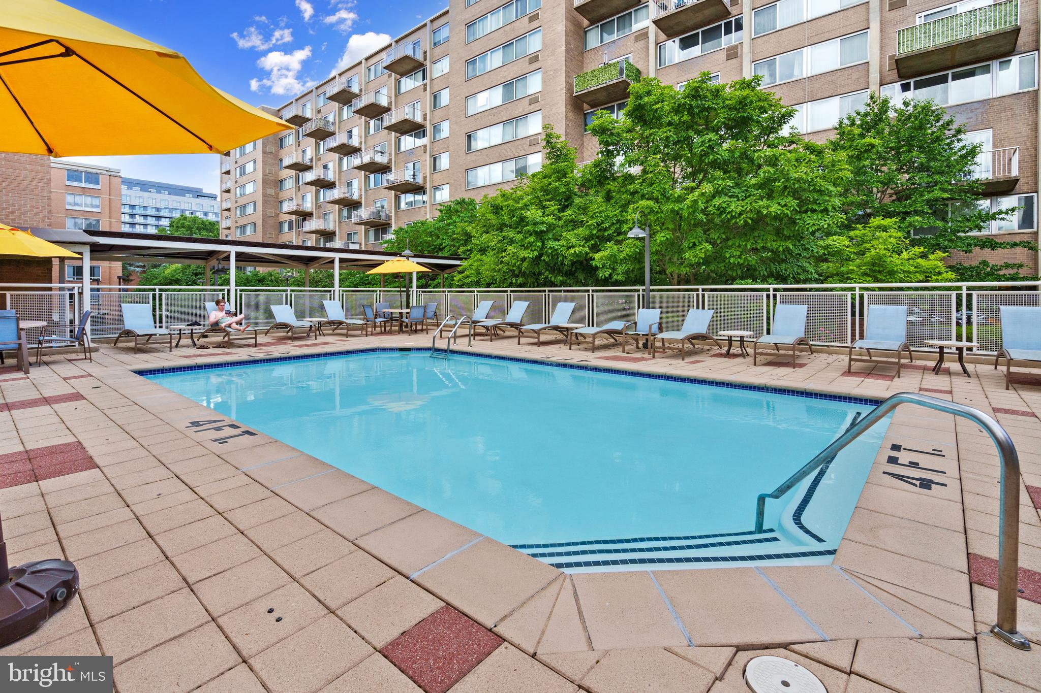 800 4th Street Southwest, Unit S421 Washington, DC 20024 - Photo 18 of 30 a view of a swimming pool with a bench and trees in the background