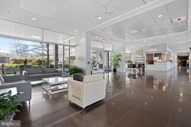 a living room with furniture wooden floor and a large window