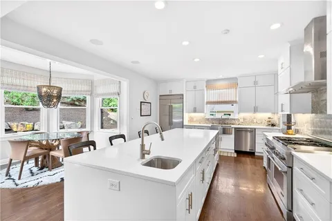 a kitchen with counter top space a sink stainless steel appliances and windows