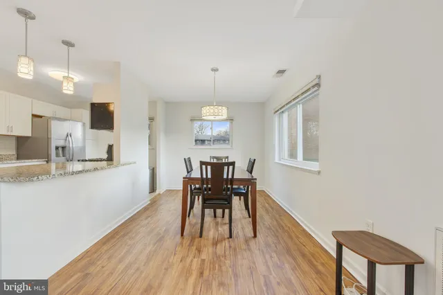a dining room with wooden floor and a chandelier