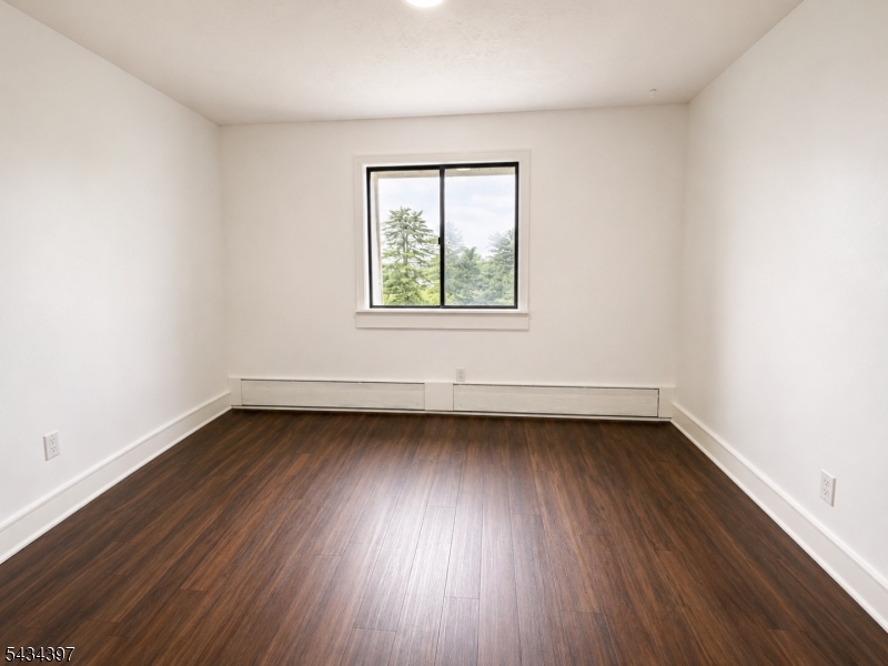 207 Old Chimney Ridge Road, Unit L Montague, NJ 07827 - Photo 8 of 14 an empty room with wooden floor and windows