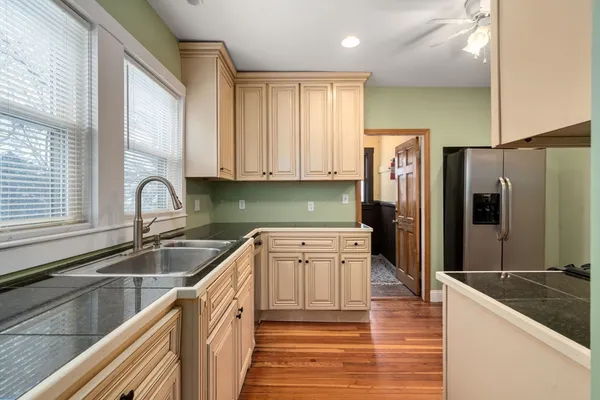 a kitchen with granite countertop a refrigerator and a sink
