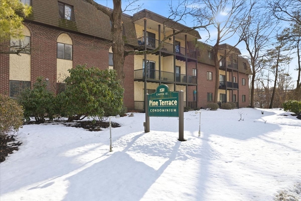 a street sign on a sidewalk next to a building
