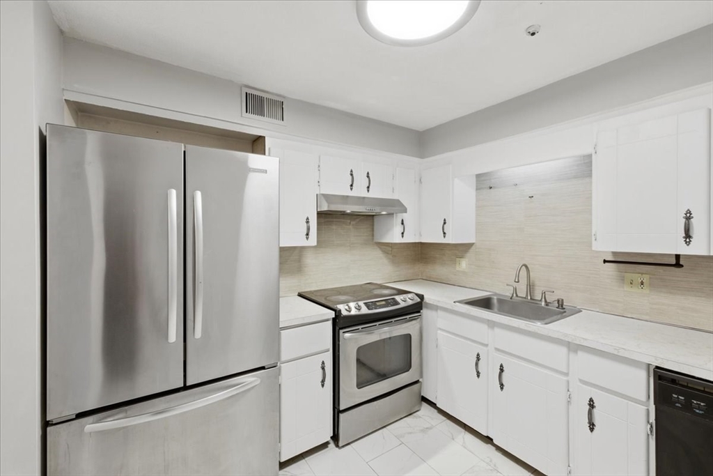 232 Canton Street, Unit 308 Randolph, MA 02368 - Photo 11 of 41 a kitchen with white cabinets and white appliances