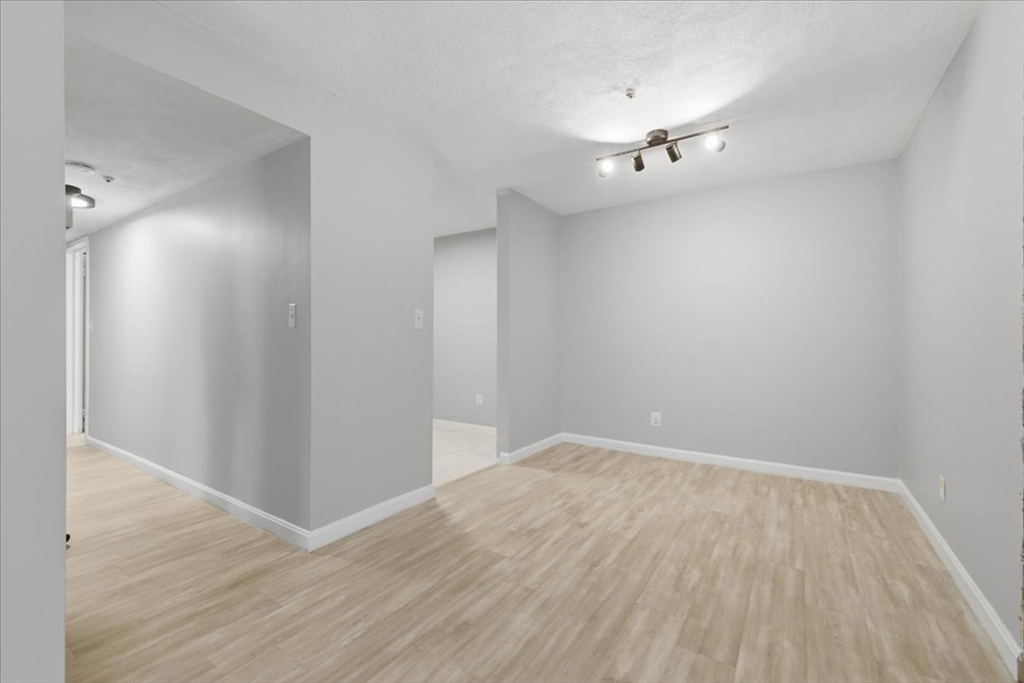 232 Canton Street, Unit 308 Randolph, MA 02368 - Photo 14 of 41 a view of an empty room with wooden floor