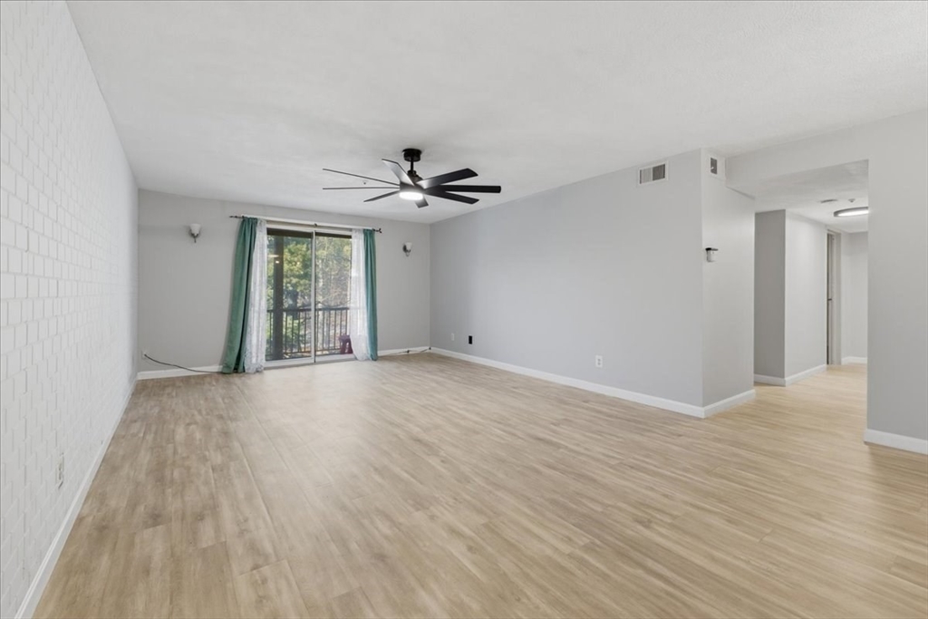 232 Canton Street, Unit 308 Randolph, MA 02368 - Photo 2 of 41 a view of an empty room with wooden floor and a window
