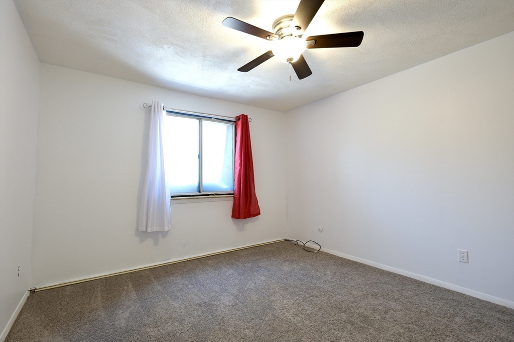232 Canton Street, Unit 308 Randolph, MA 02368 - Photo 23 of 41 an empty room with windows and fan