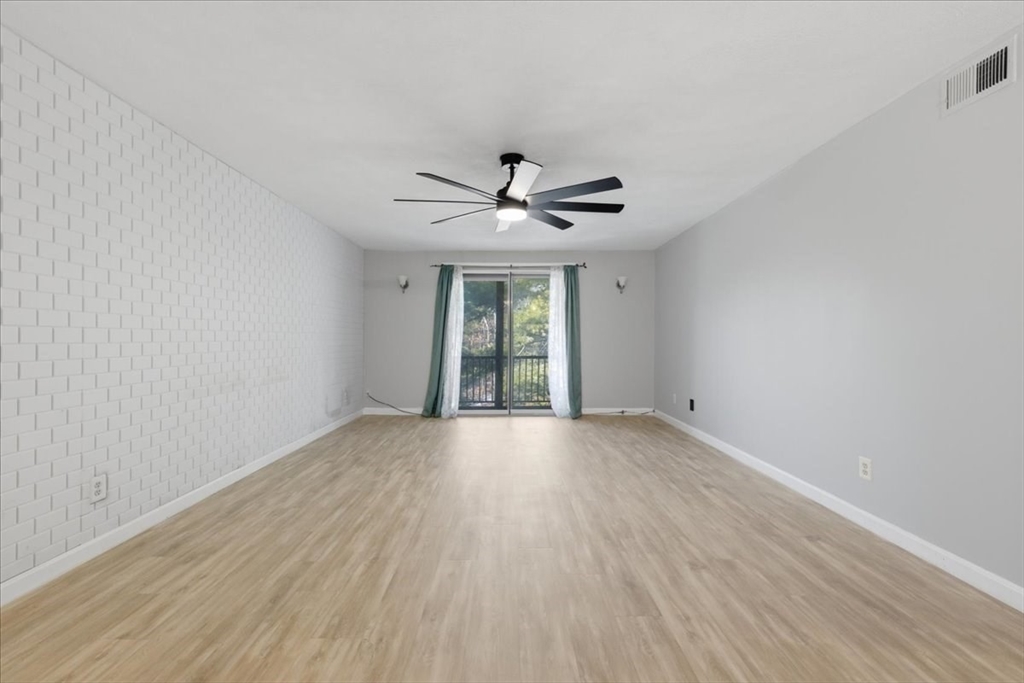 232 Canton Street, Unit 308 Randolph, MA 02368 - Photo 6 of 41 a view of an empty room with wooden floor and a window