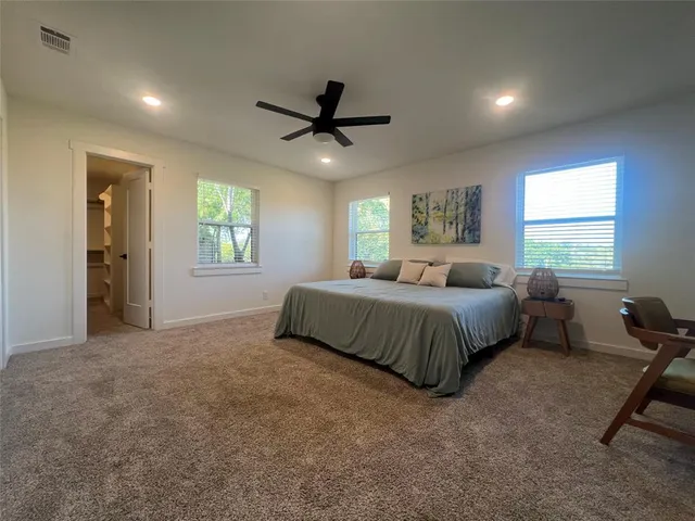 a spacious bedroom with a bed and windows