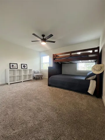 a living room with furniture and a ceiling fan
