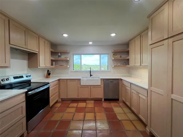 a kitchen with a sink a stove top oven and cabinets
