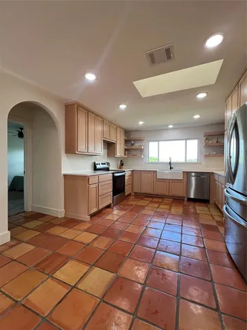 a large kitchen with stainless steel appliances lots of counter top space and cabinets