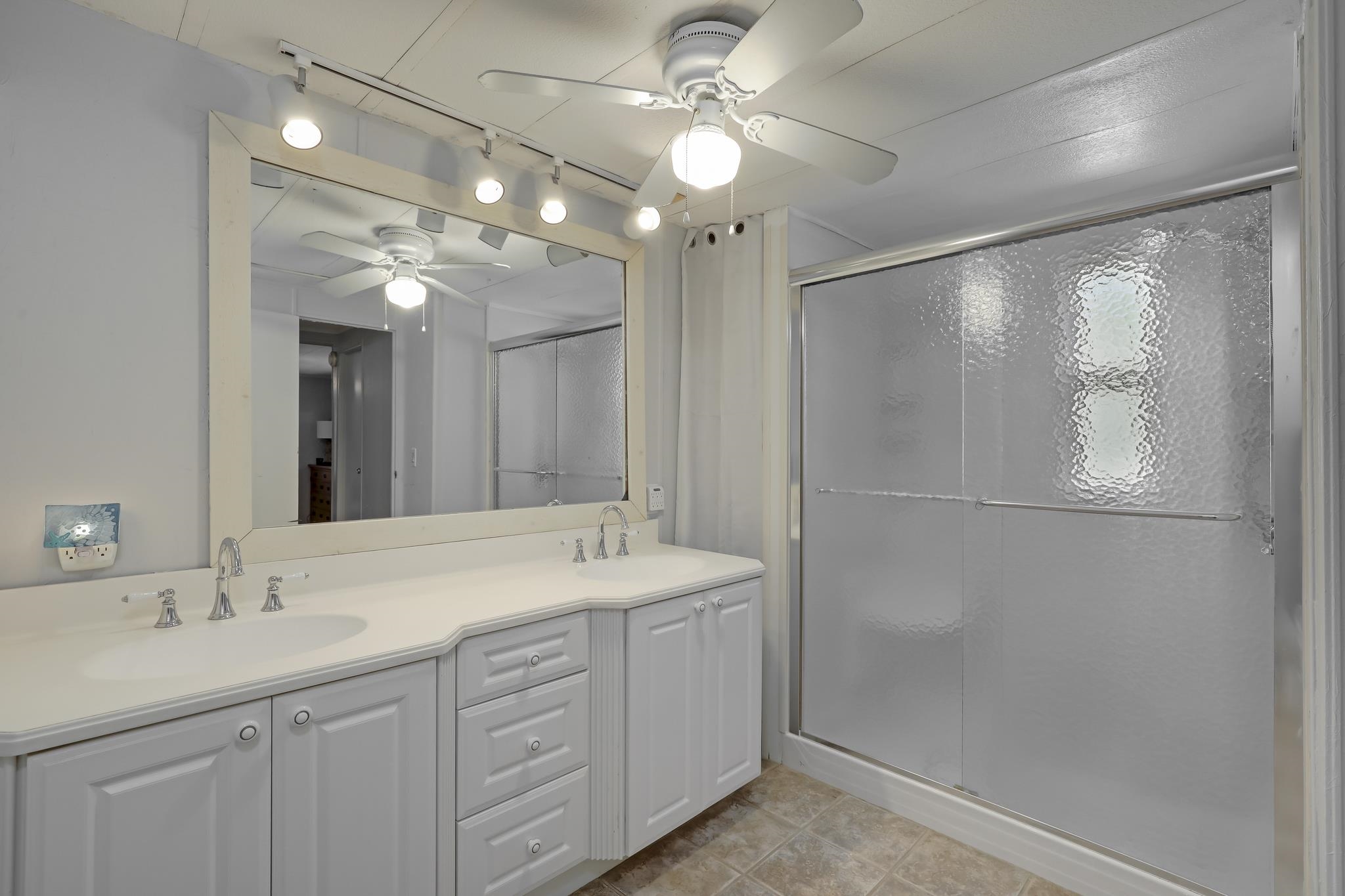 6901 Catlett Road St. Augustine, FL 32095 - Photo 24 of 74 Bathroom with double vanity, a shower stall, rail lighting, and a ceiling fan
