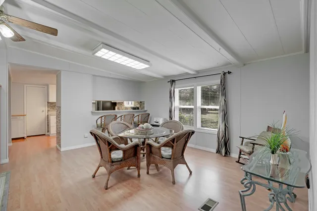 a dining room with furniture a chandelier and wooden floor