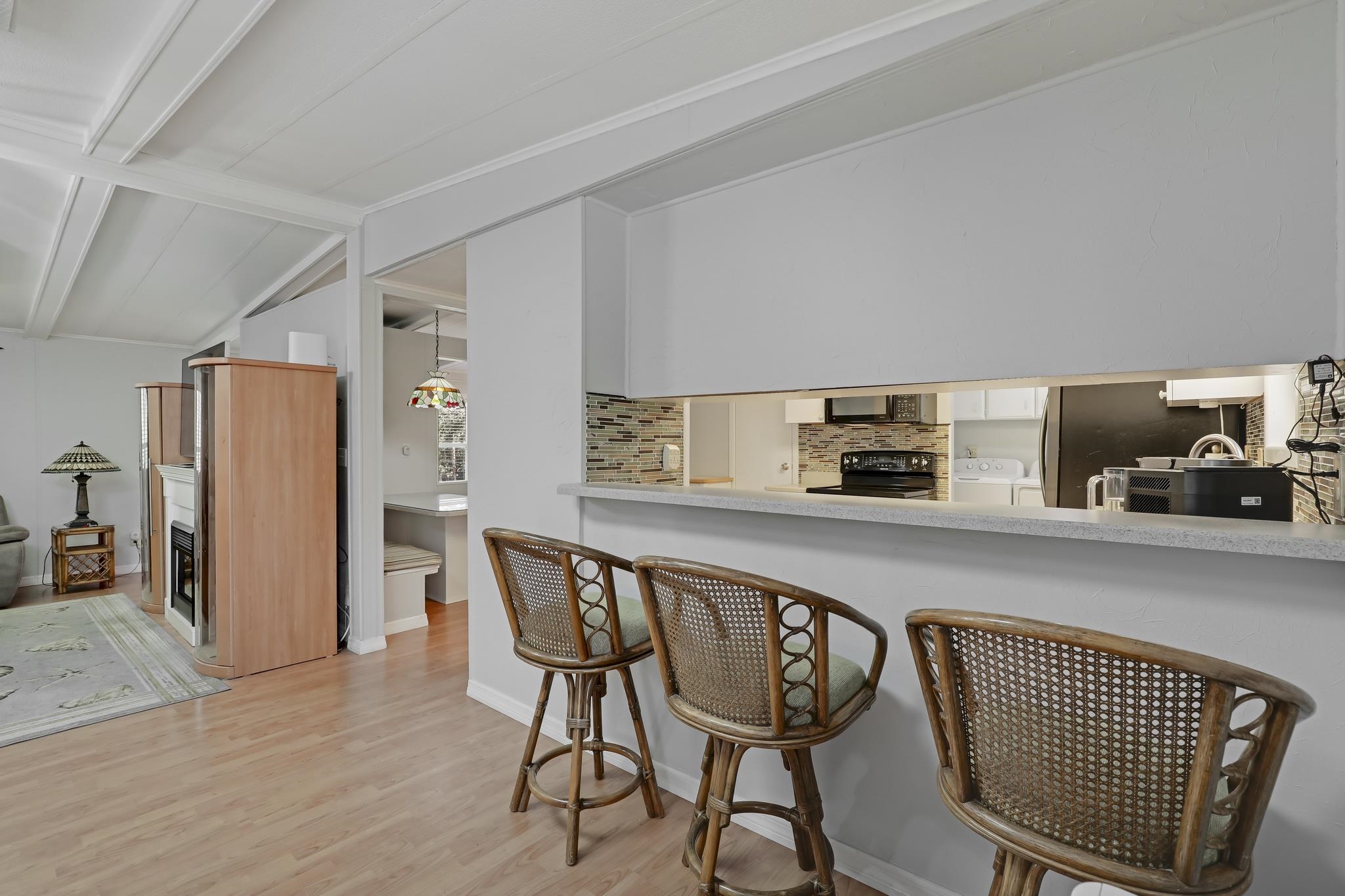 6901 Catlett Road St. Augustine, FL 32095 - Photo 27 of 74 Kitchen featuring a breakfast bar, light countertops, light wood-type flooring, washer and dryer, and black / electric stove