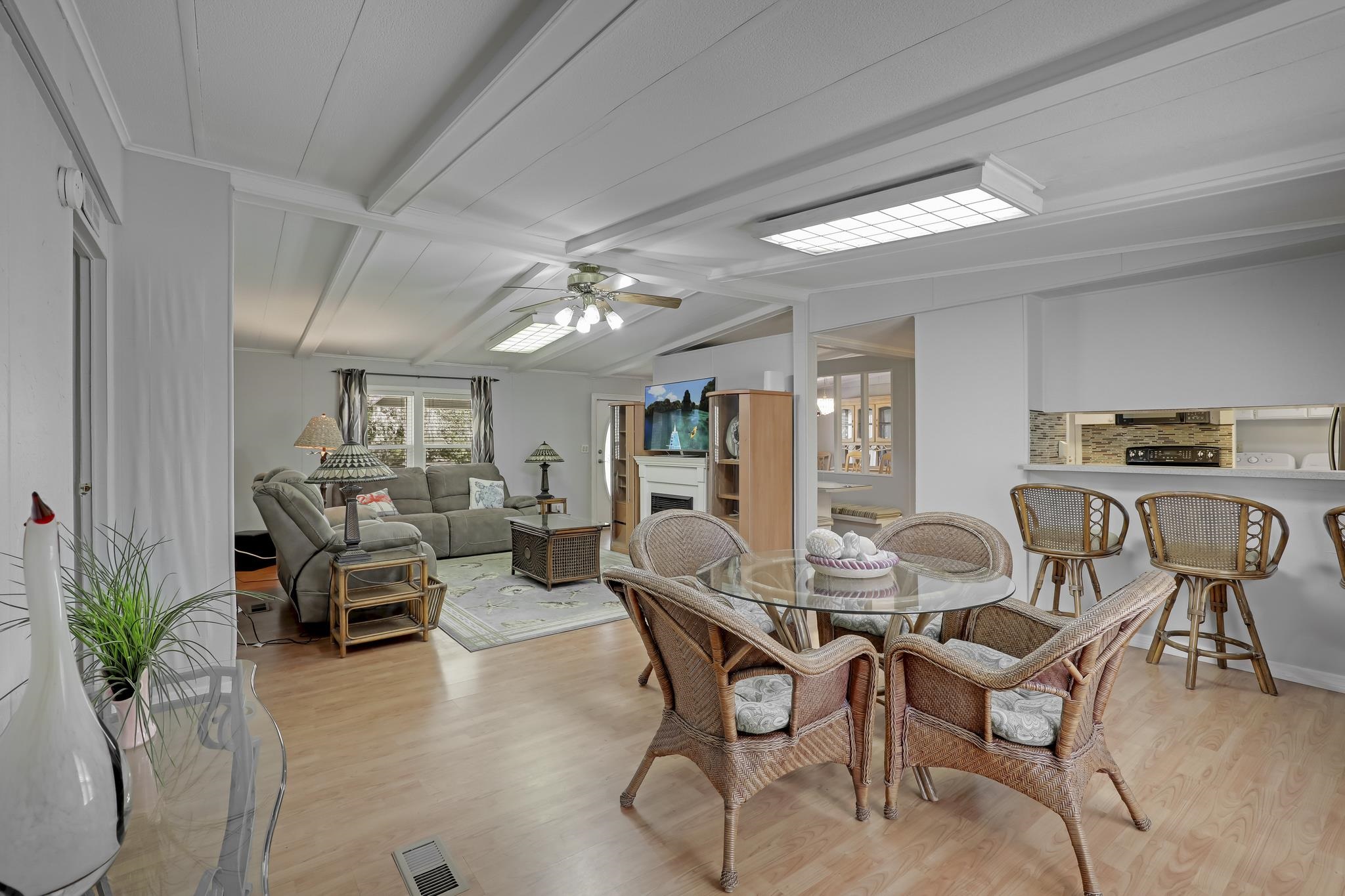6901 Catlett Road St. Augustine, FL 32095 - Photo 6 of 74 Dining space with light wood-style flooring, lofted ceiling with beams, a fireplace, and a ceiling fan