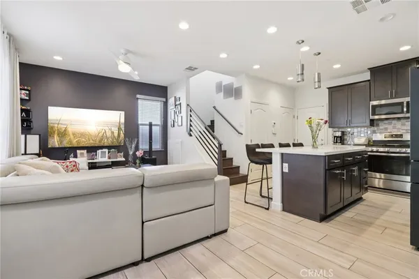 a kitchen with stainless steel appliances kitchen island granite countertop a stove a sink and a refrigerator