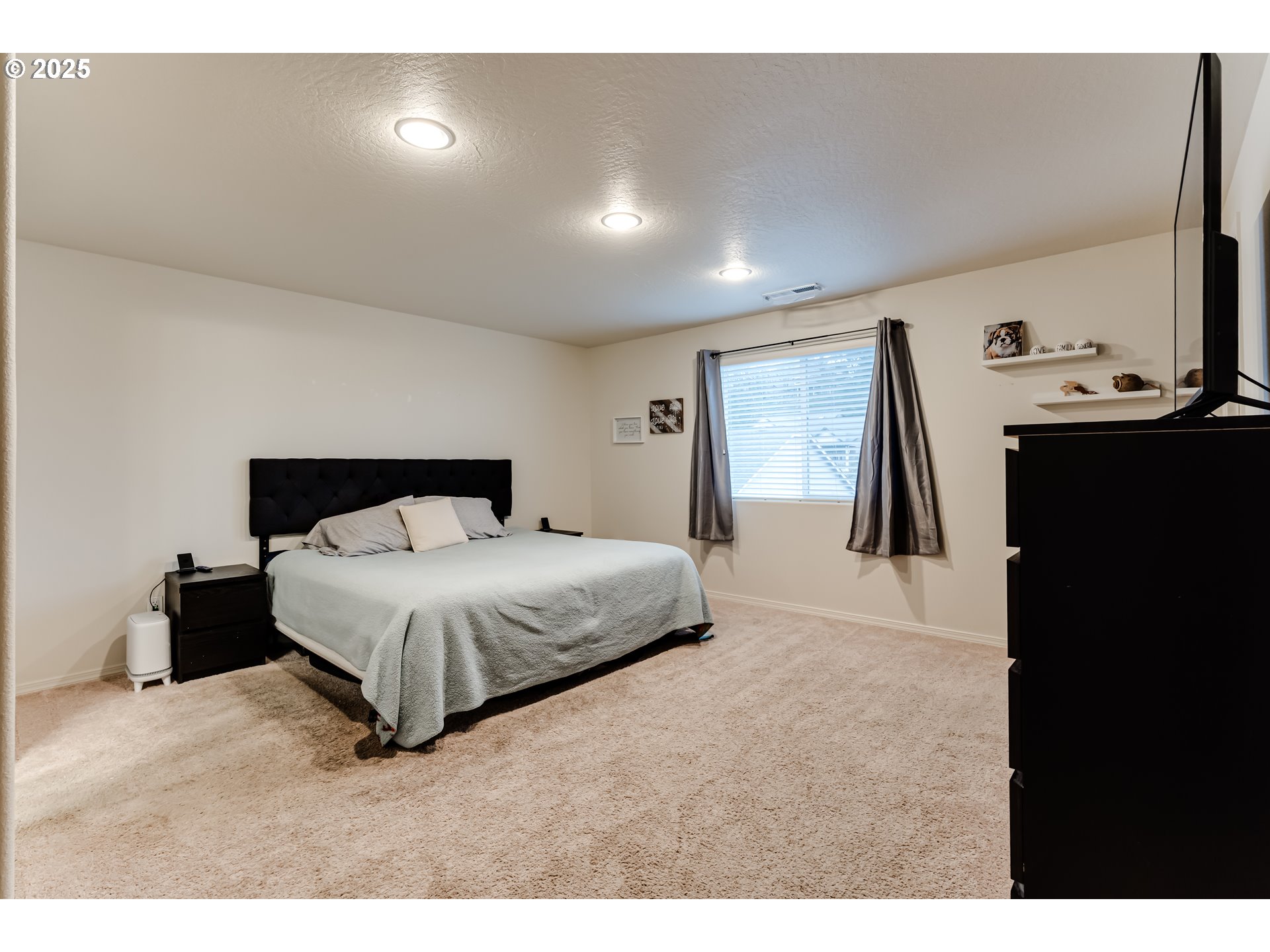4685 Glacier Meadows Loop Springfield, OR 97478 - Photo 19 of 28 a bedroom with a bed and a flat tv screen on the dresser