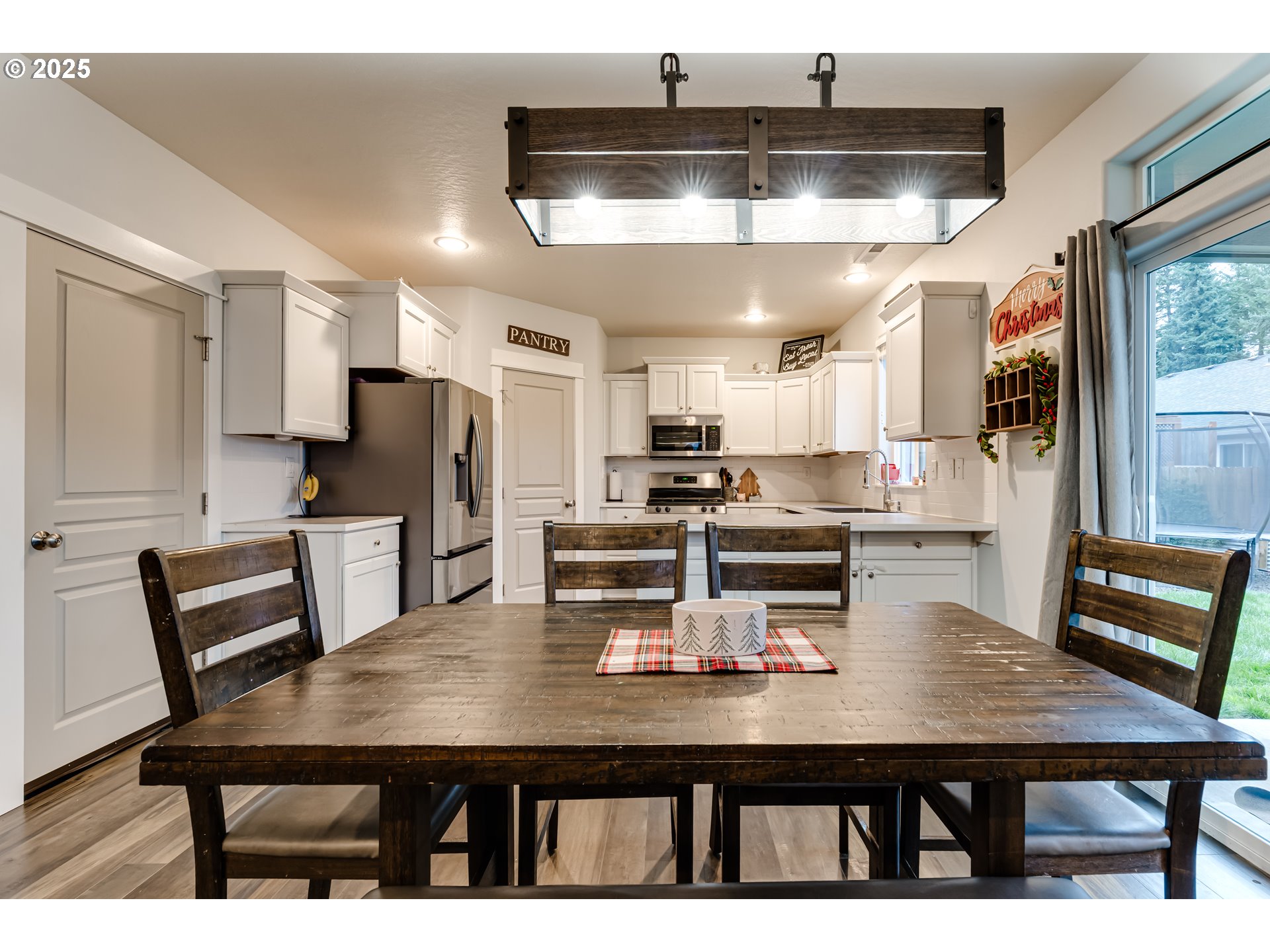 4685 Glacier Meadows Loop Springfield, OR 97478 - Photo 5 of 28 a kitchen with a table chairs refrigerator and cabinets