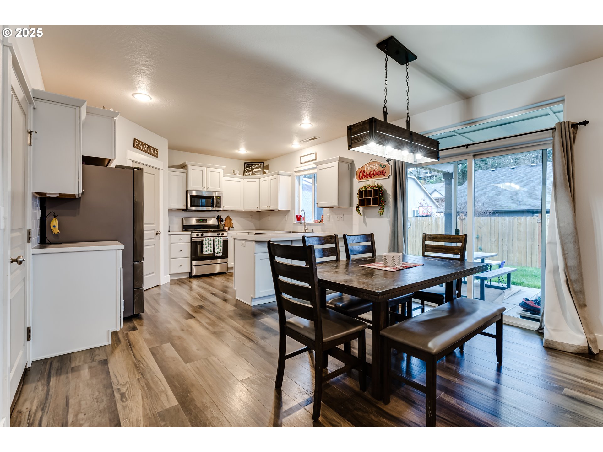 4685 Glacier Meadows Loop Springfield, OR 97478 - Photo 6 of 28 a kitchen with stainless steel appliances kitchen island granite countertop a table chairs and a refrigerator