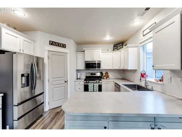 a kitchen with stainless steel appliances granite countertop a refrigerator sink and stove