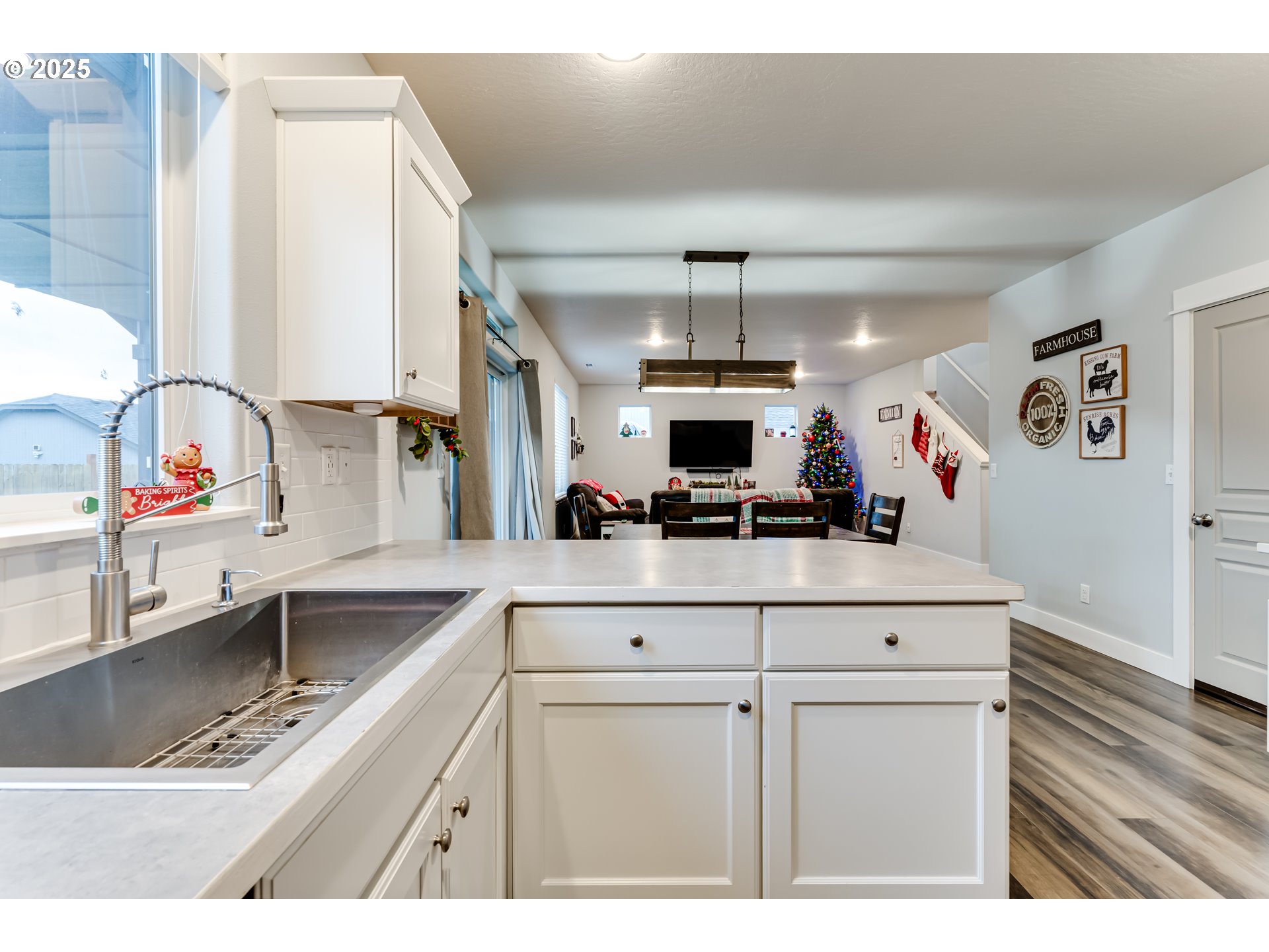 4685 Glacier Meadows Loop Springfield, OR 97478 - Photo 8 of 28 a kitchen with stainless steel appliances kitchen island granite countertop a sink a stove and white cabinets