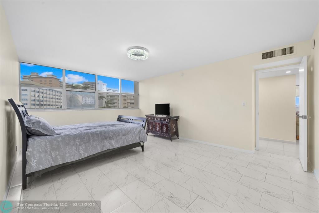 100 Golden Isles Drive, Unit 313 Hallandale Beach, FL 33009 - Photo 12 of 33 a bedroom with a bed and a cabinets