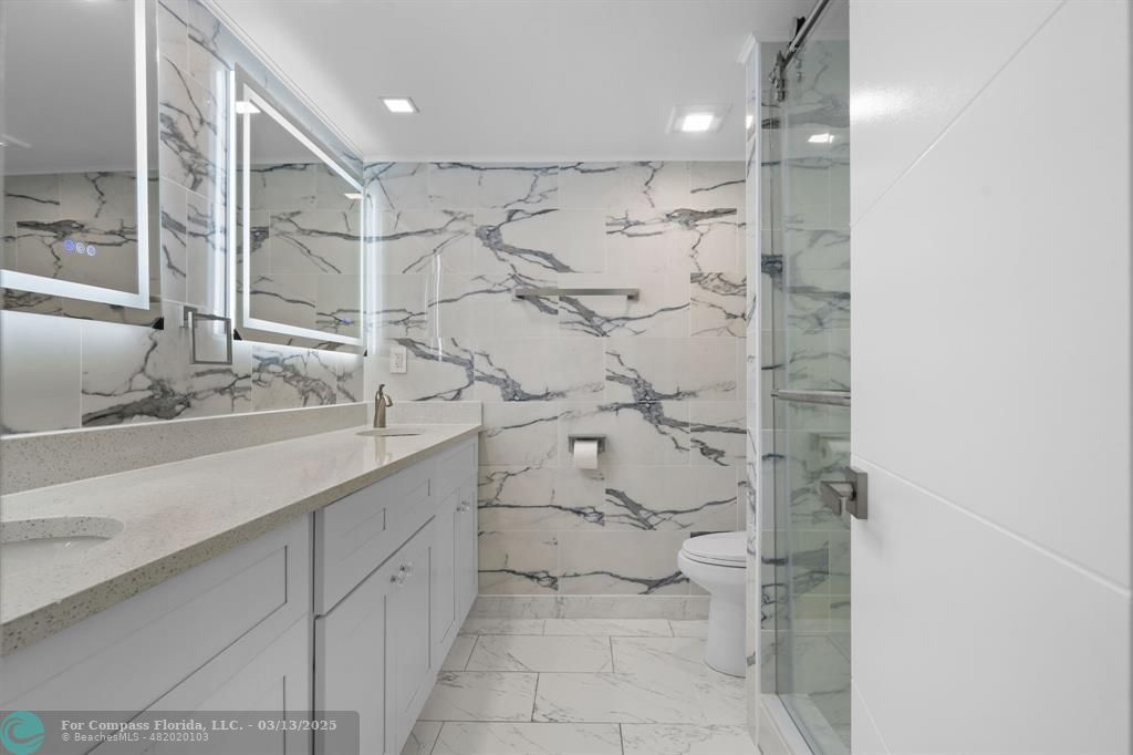 100 Golden Isles Drive, Unit 313 Hallandale Beach, FL 33009 - Photo 14 of 33 a bathroom with a granite countertop sink mirror and shower
