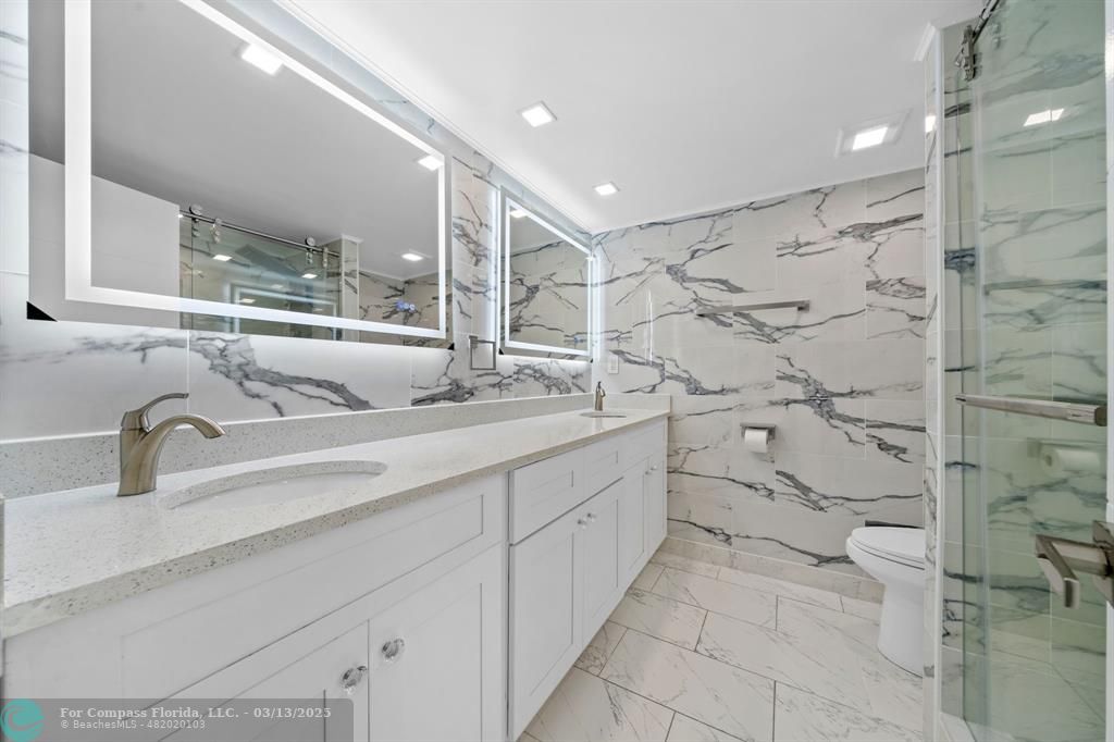 100 Golden Isles Drive, Unit 313 Hallandale Beach, FL 33009 - Photo 15 of 33 a bathroom with a double vanity sink mirror and shower