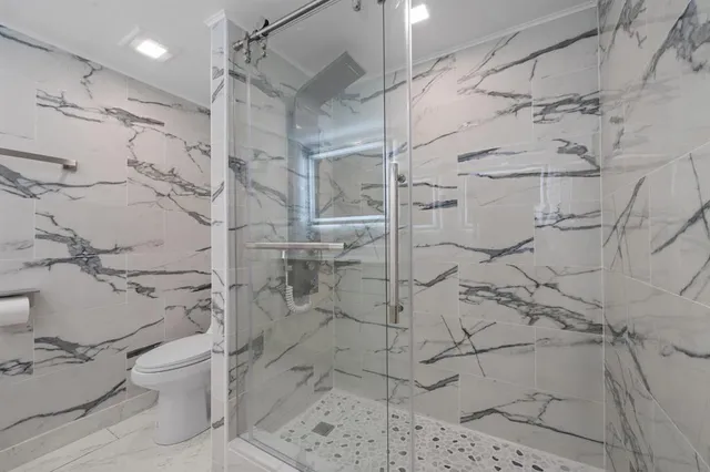 a bathroom with a shower toilet and sink