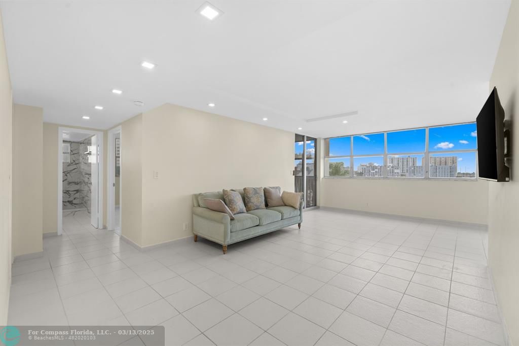 100 Golden Isles Drive, Unit 313 Hallandale Beach, FL 33009 - Photo 19 of 33 a living room with furniture and a flat screen tv