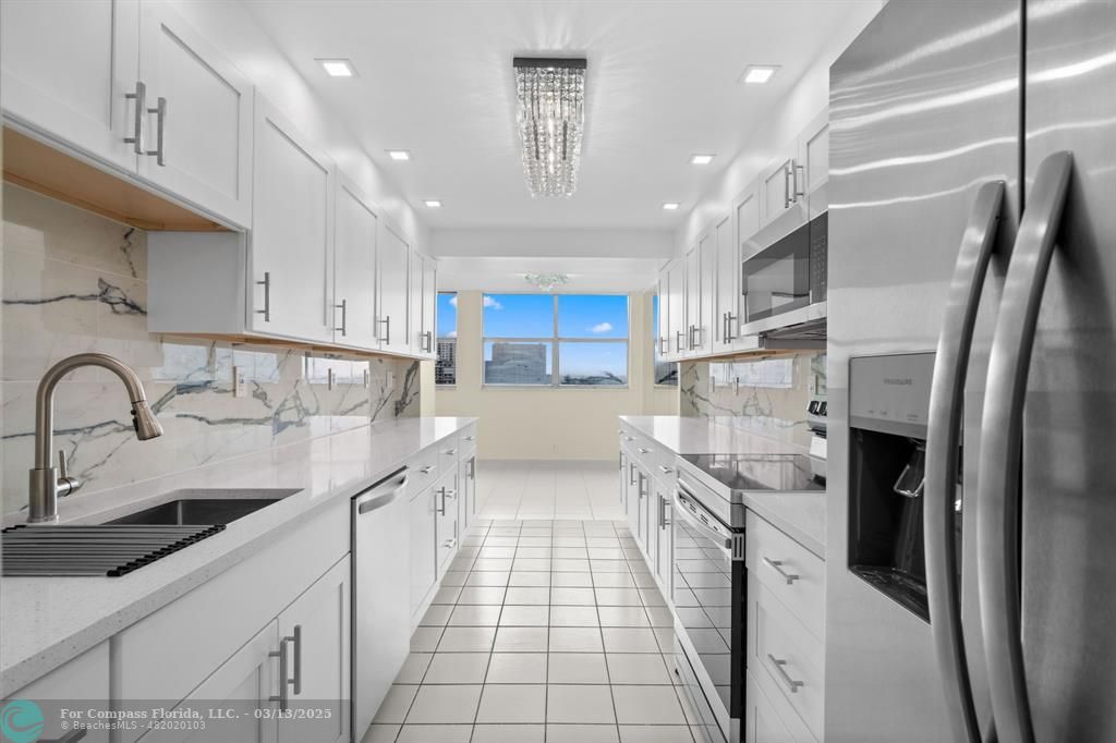 100 Golden Isles Drive, Unit 313 Hallandale Beach, FL 33009 - Photo 24 of 33 a kitchen with stainless steel appliances a refrigerator sink and cabinets