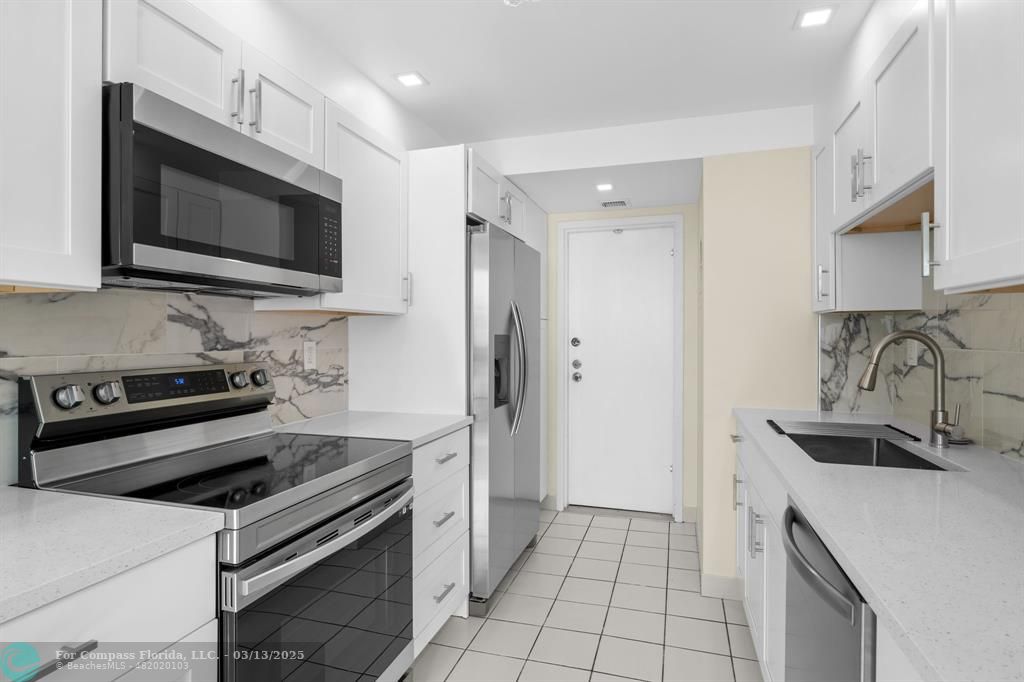 100 Golden Isles Drive, Unit 313 Hallandale Beach, FL 33009 - Photo 25 of 33 a kitchen with a stove and a microwave