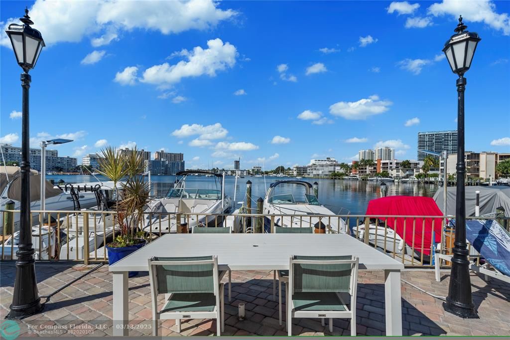 100 Golden Isles Drive, Unit 313 Hallandale Beach, FL 33009 - Photo 32 of 33 a view of a patio with swimming pool table and chairs