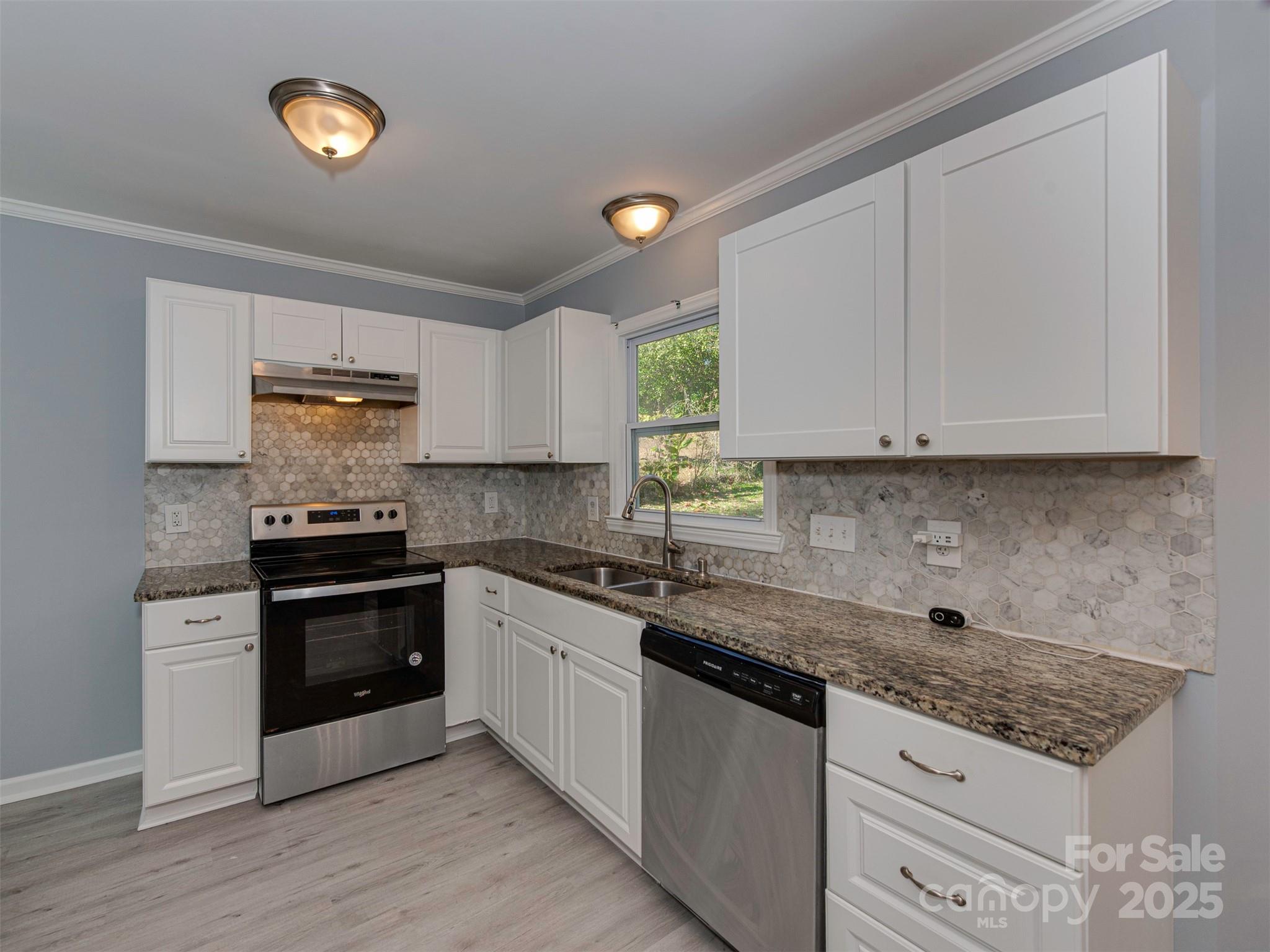7413 Lockmont Drive Charlotte, NC 28212 - Photo 14 of 42 a kitchen with granite countertop a stove top oven sink and cabinets