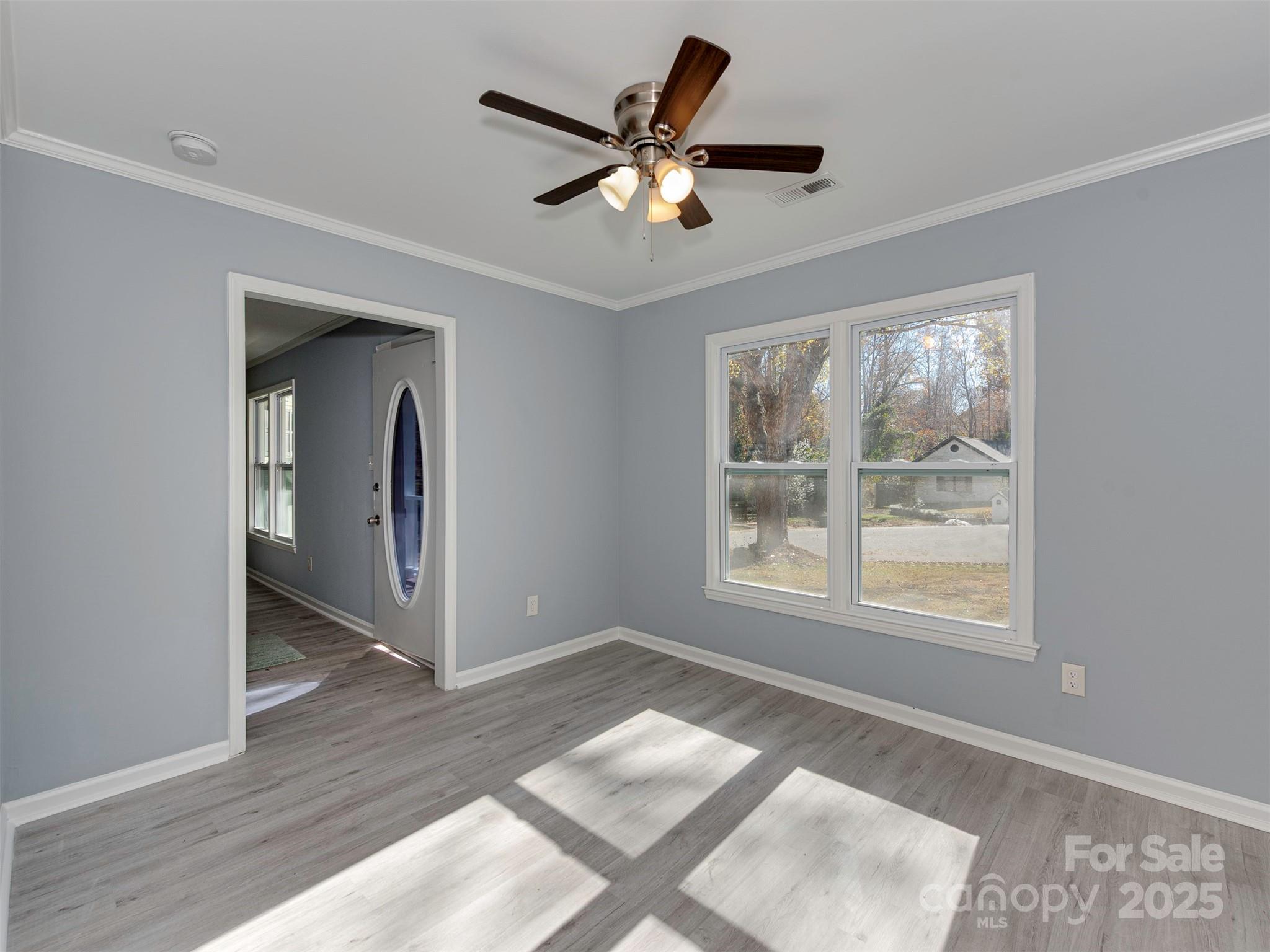 7413 Lockmont Drive Charlotte, NC 28212 - Photo 7 of 42 a view of an empty room with a window and wooden floor
