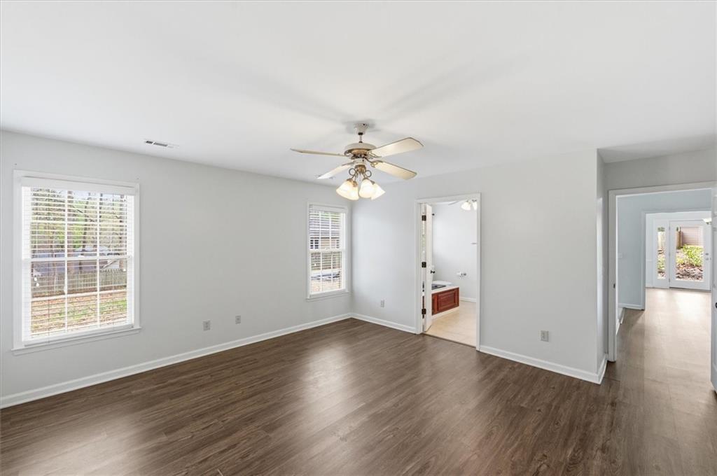 139 Stanbrough Drive Dallas, GA 30157 - Photo 35 of 52 an empty room with wooden floor chandelier fan and windows
