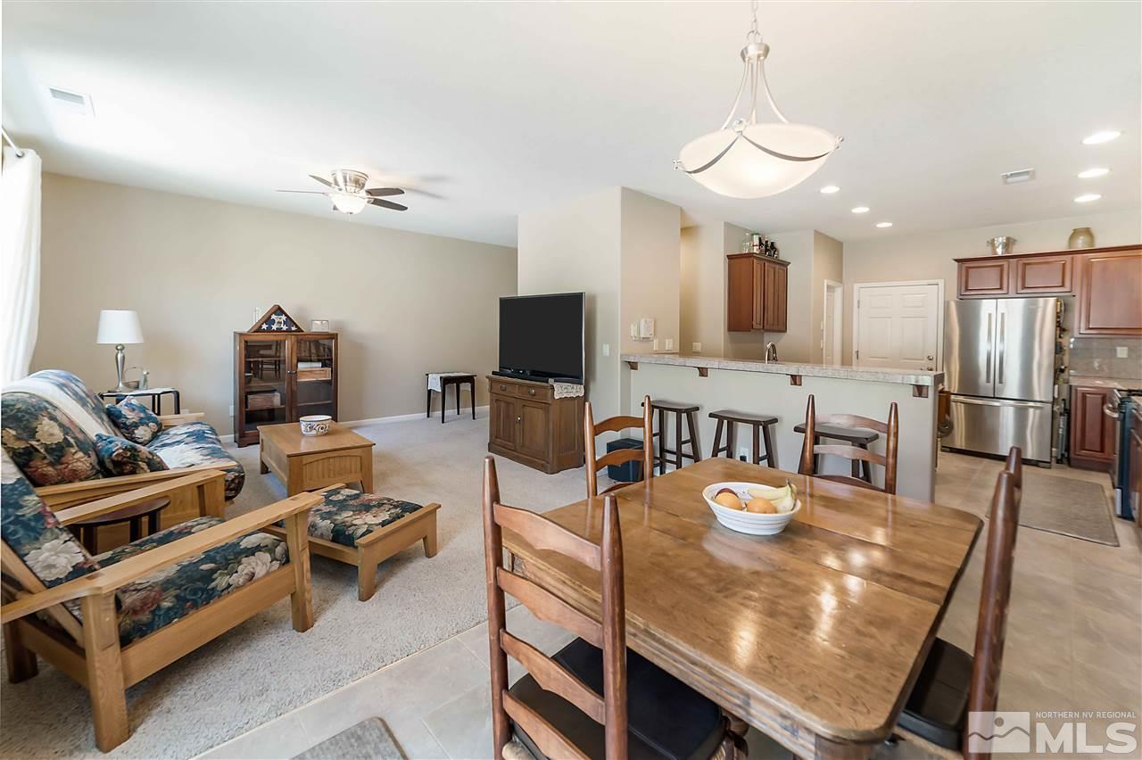 1875 Stetson Drive Reno, NV 89521 - Photo 14 of 27 a kitchen with stainless steel appliances granite countertop a stove a refrigerator a sink a dining table and chairs with wooden floor