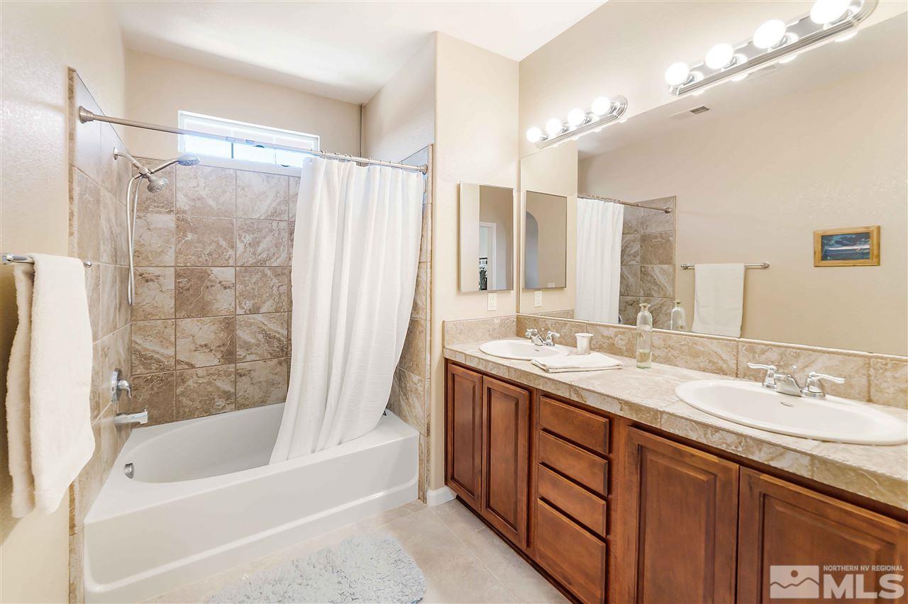 1875 Stetson Drive Reno, NV 89521 - Photo 17 of 27 a bathroom with a granite countertop sink mirror and a bathtub