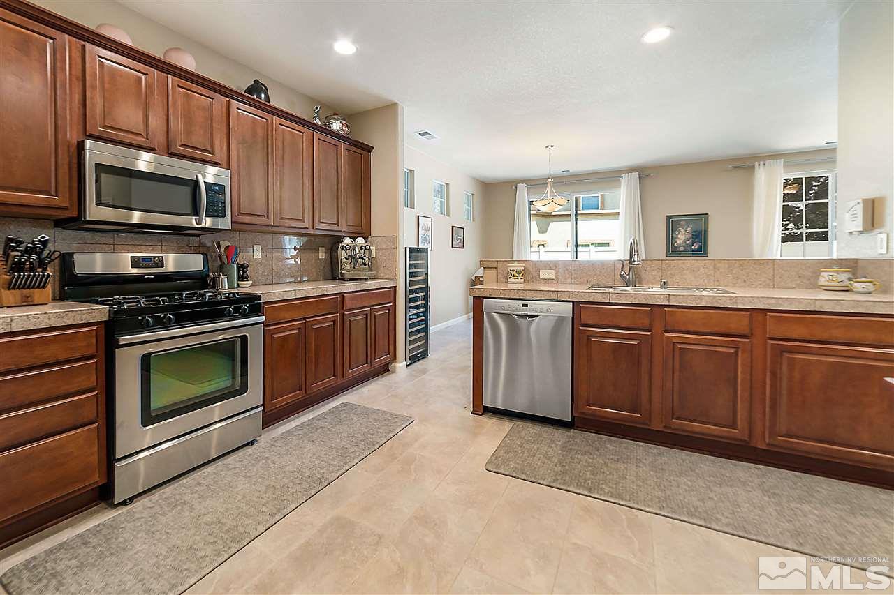 1875 Stetson Drive Reno, NV 89521 - Photo 3 of 27 a kitchen with stainless steel appliances granite countertop a stove top oven a sink dishwasher and a microwave oven on the blue kitchen countertops